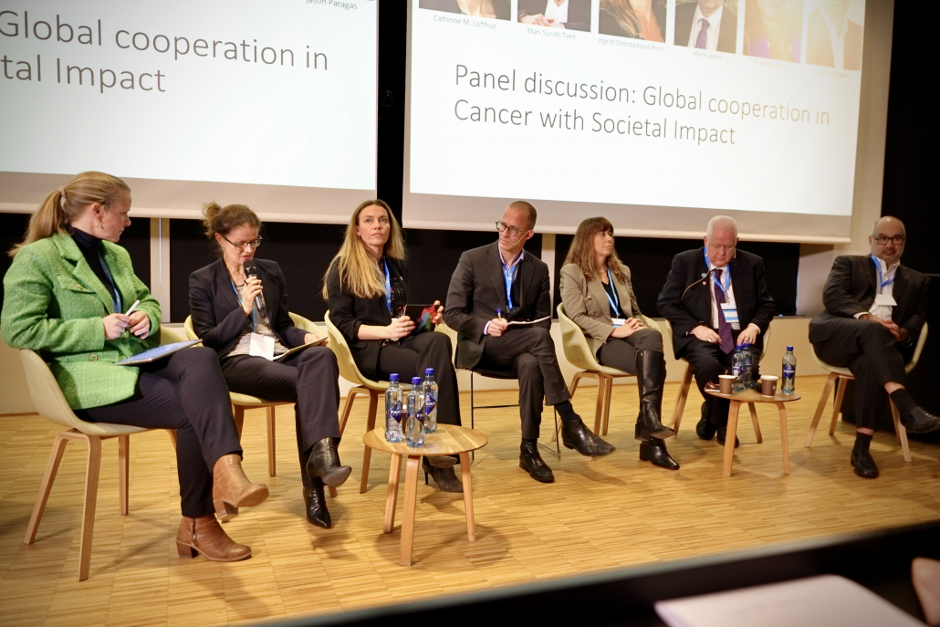 seven people sitting on stage in a panel discussion 