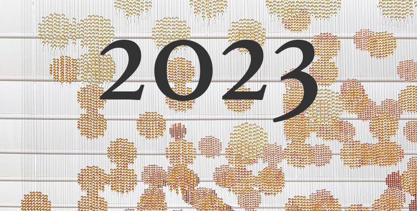 2023 written in front of circles of pearls in variants of red and orange.